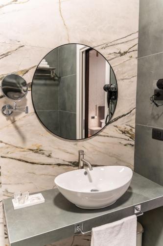 a bathroom with a sink and a mirror at Ambrosia Room & Apartment in Rossano