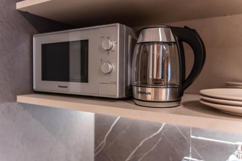 a microwave and a coffee maker on a shelf at Ambrosia Room & Apartment in Rossano