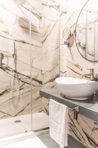 a bathroom with a sink and a mirror at Ambrosia Room & Apartment in Rossano