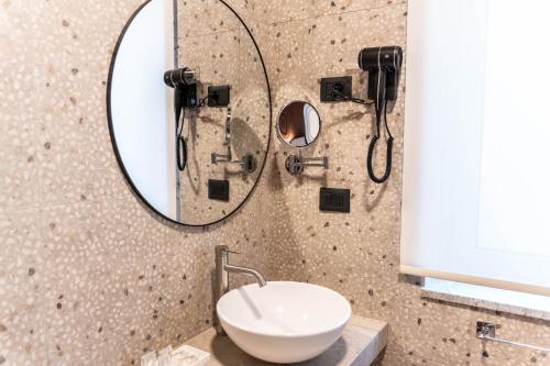 a bathroom with a sink and a mirror at Ambrosia Room & Apartment in Rossano