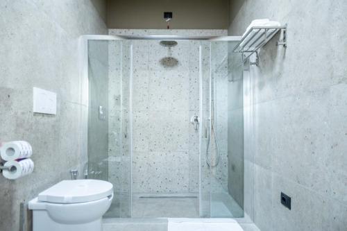 a bathroom with a glass shower with a toilet at Ambrosia Room & Apartment in Rossano
