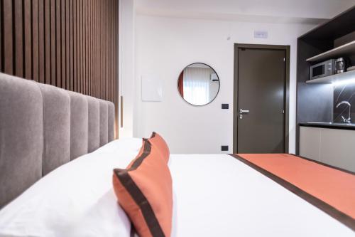 a bedroom with a large bed and a kitchen at Ambrosia Room & Apartment in Rossano