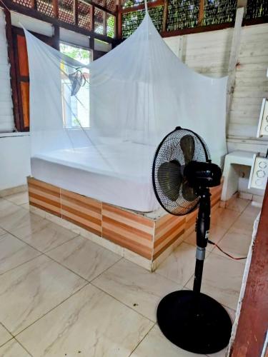 a fan in a room with a bed at Eco Hotel Campo Verde in Isla Grande