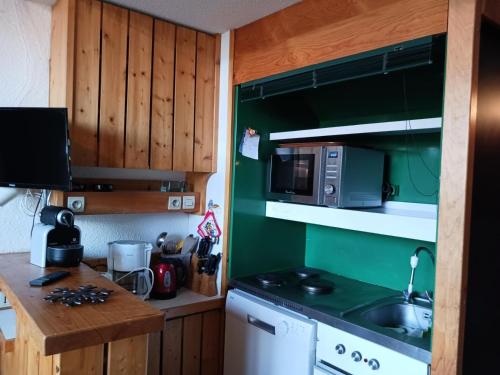une petite cuisine avec un évier et un micro-ondes dans l'établissement Résidence Archeboc - Appartement 5 personnes à Arc 1800 proche des pistes dans le village de Charmettoger MAE-1031, à Arc 1800