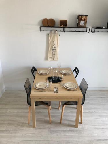 a wooden table with chairs and plates and wine glasses at Baker's house in Clermont-Ferrand