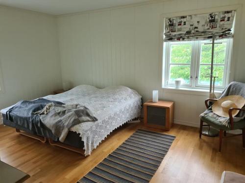 a bedroom with a bed and a chair and a window at Stort landsted med egen strand in Rød