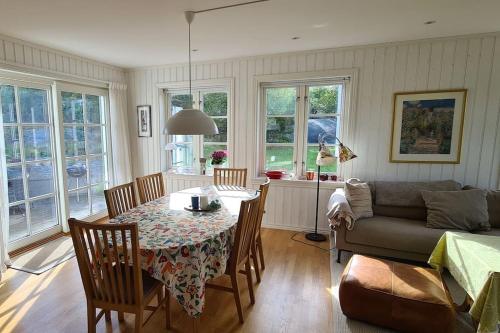 a living room with a table and a couch at Stort landsted med egen strand in Rød