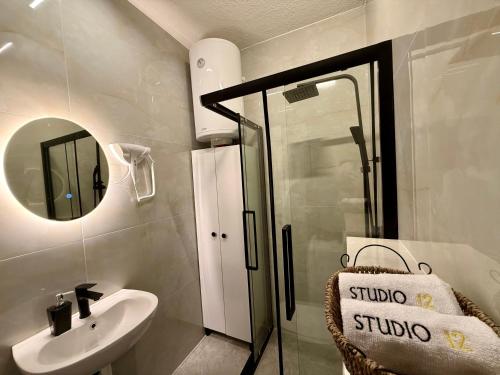 a bathroom with a sink and a mirror at Studio 12 Prishtina in Pristina
