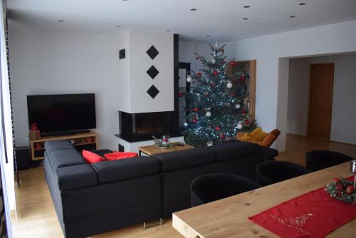 a living room with a christmas tree and a couch at Apartamenty Kotarz Sauna&Relaks in Brenna