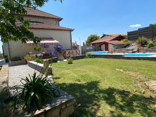 une cour avec une chaise en face d'une maison dans l'établissement gîte porte de la bastide, à Hastingues