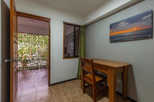 a dining room with a wooden table and a window at Jaco Laguna Resort & Beach Club in Jacó