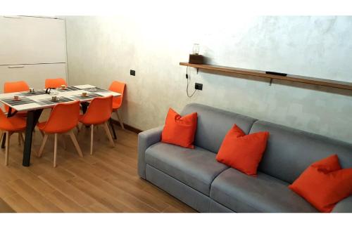Pokój z kanapą i stołem z pomarańczowymi poduszkami w obiekcie Orange Fox Cervinia apartment Vda Vacanze in Vetta CIR 0185 w mieście Breuil-Cervinia