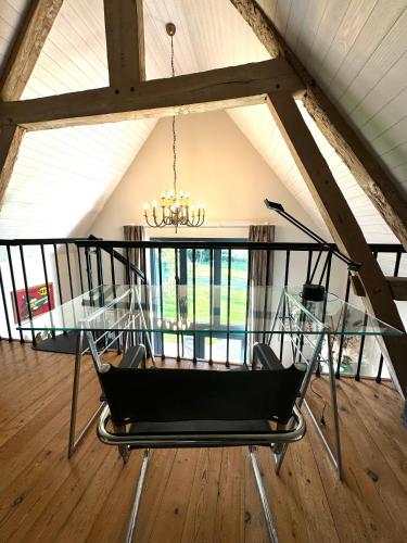 a dining room with a glass table and a chandelier at Le Cottage enchanteur du Renouard avec sa Vue panoramique in Le Renouard