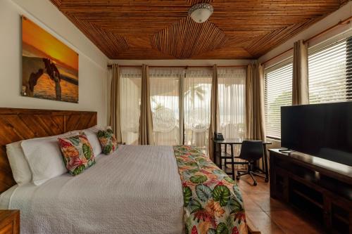 a bedroom with a bed and a flat screen tv at Jaco Laguna Resort & Beach Club in Jacó