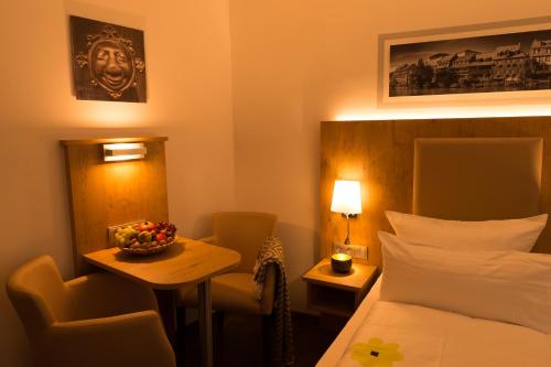 a hotel room with a bed and a table with a bowl of fruit at Ferienwohnung am Griesgarten in Bamberg