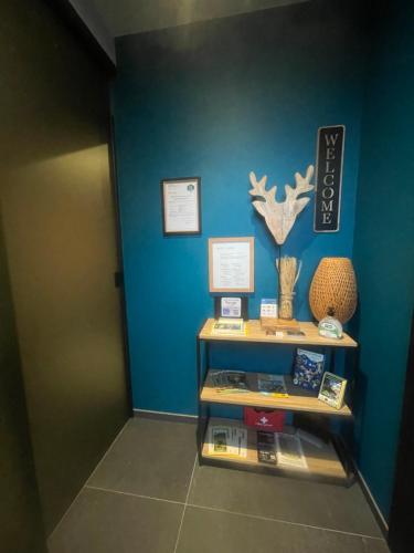 a shelf in a room with a blue wall at B&B Les Épis in Marche-en-Famenne