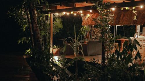 a patio at night with a table and lights at Boatique Hotel and Marina in Rio Dulce