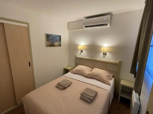 une chambre avec un lit avec deux serviettes dessus dans l'établissement CANNES FRANCIA Superbe F3 balcon vue mer piscine, à Cannes