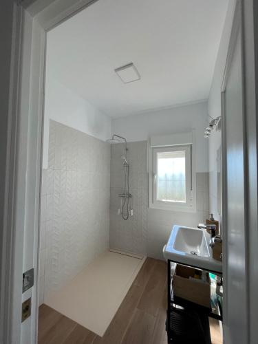 a white bathroom with a sink and a window at Villa Mariaje in Cazalla de la Sierra