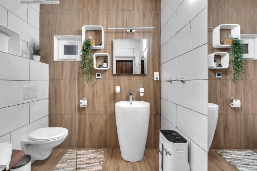 a bathroom with a toilet and a sink and mirrors at Apartment Villa Hřensko 132 in Hřensko