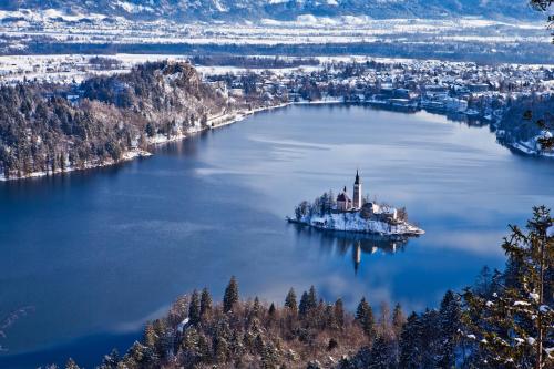 an island with a church in the middle of a lake at Rikli Balance Hotel – Sava Hotels & Resorts in Bled