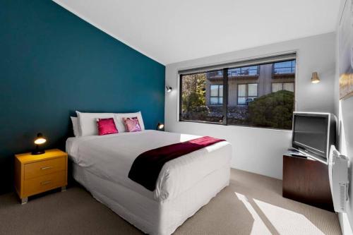 a bedroom with a large bed and a window at Remarkable Views 3 bedroom - lake & mountain views in Queenstown