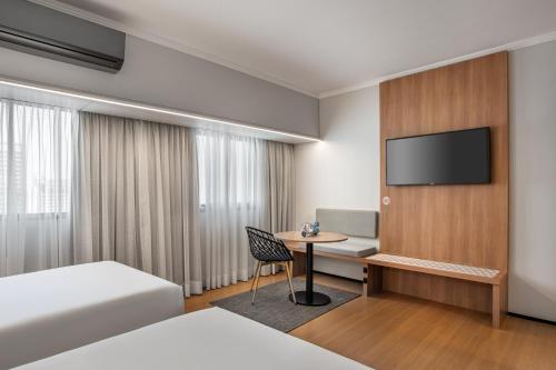 a hotel room with a desk and a tv at INNSiDE by Meliá São Paulo Iguatemi in Sao Paulo