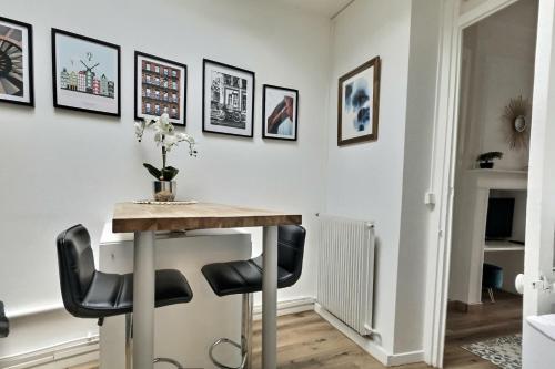 une salle à manger avec une table et des chaises noires dans l'établissement Résidence Le Guyencourt Amiens Centre, à Amiens
