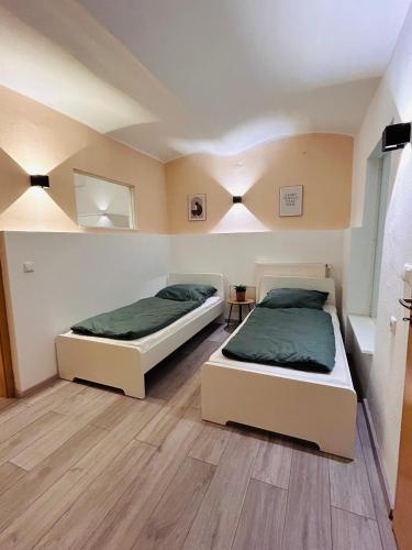 two beds sitting in a room with at Gemütliches Apartment - beste Lage in Kassel