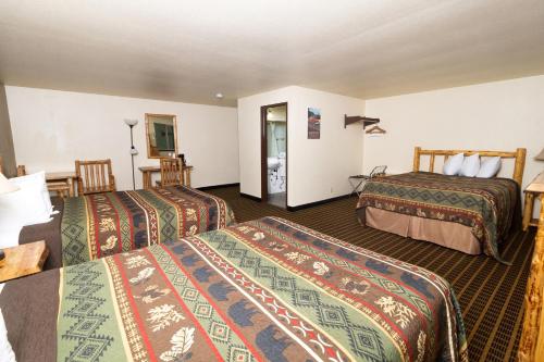a hotel room with three beds in a room at FairBridge Inn and Suites Sandpoint in Ponderay