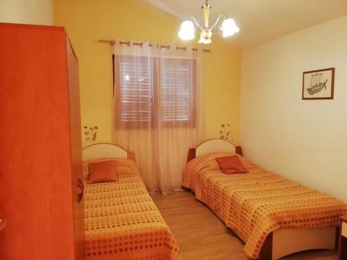 sypialnia z dwoma łóżkami i oknem w obiekcie Apartment Ljilja w mieście Zaton
