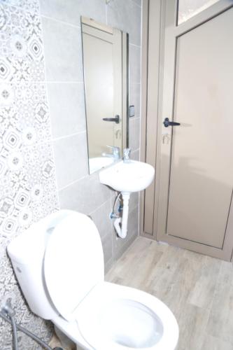 a white bathroom with a toilet and a sink at Nomad surf lodge 2 in Imsouane