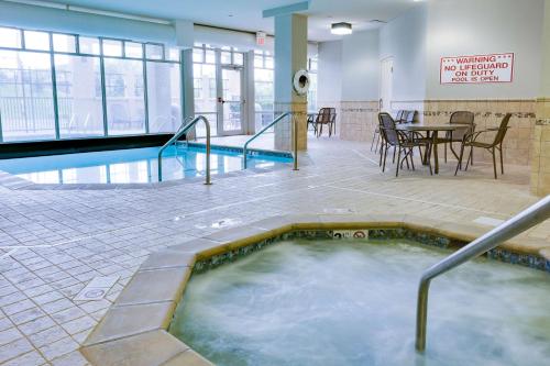 a hot tub in a room with a table and chairs at Drury Inn & Suites Middletown Franklin in Middletown