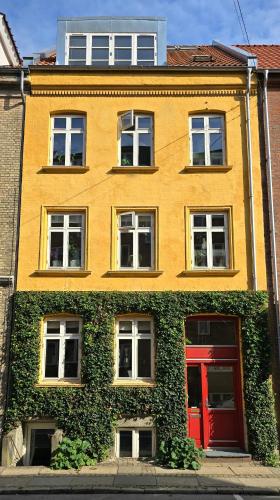 a yellow building with a red door at Townhouse in the Center Free Parking in Aalborg