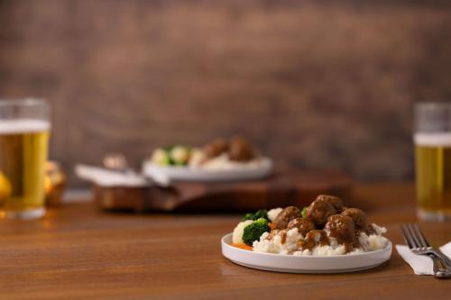 two plates of food on a wooden table with beer at Drury Inn & Suites Montgomery in Montgomery