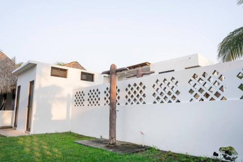 a white house with a fence at Playa Monterrico, Candelaria2 in Taxisco
