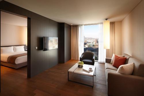 a hotel room with a bed and a couch and a table at Shilla Stay Gwanghwamun Myeongdong in Seoul