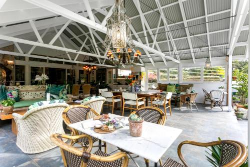 a dining room with tables and chairs and a chandelier at Noosa Valley Manor B&B in Doonan