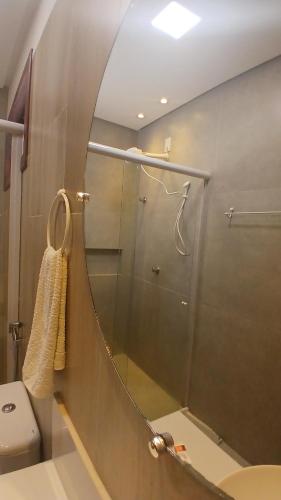a bathroom with a shower with a mirror and a toilet at Pousada Solarium in Canoa Quebrada