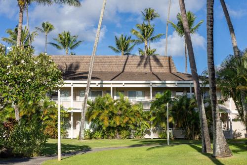 an exterior view of a resort with palm trees at Plantation Hale Suites in Kapaa