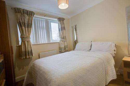 a bedroom with a white bed with a window at Free Parking 6 Beds Fully Equipped Home Favourite by Contractors & Groups in Earley