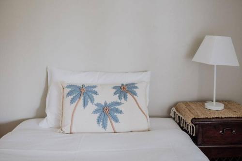 a bed with a pillow and a lamp on a table at Sentinel at Freycinet in Coles Bay