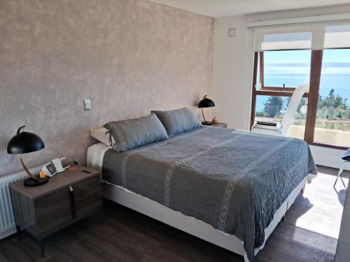 a bedroom with a bed and a large window at The sun in Tomé