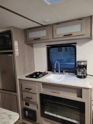 a small kitchen with a sink and a stove at Half Moon Lake property in Melrose