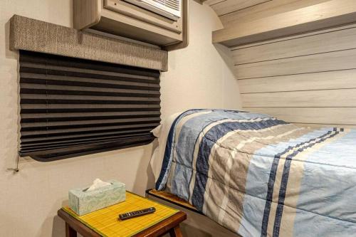 a small bedroom with a bed and a table at Half Moon Lake property in Melrose