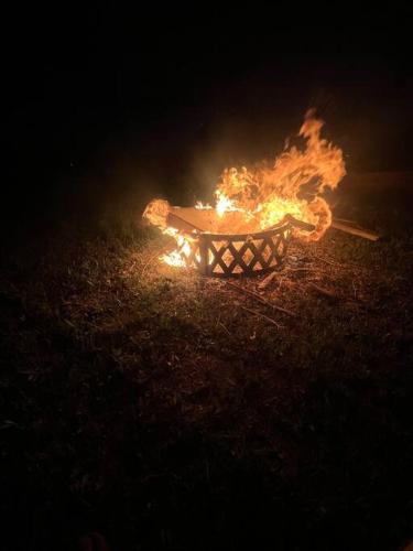 a bonfire is burning in a field at night at Half Moon Lake property in Melrose