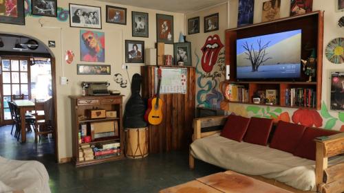 a living room with a couch and a tv at Hostel "La Casita Naranja" in El Bolsón