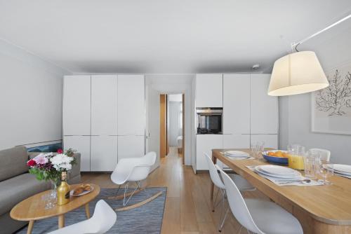 a kitchen and dining room with a table and chairs at Crawford Street Apartment By Morethanstays in London