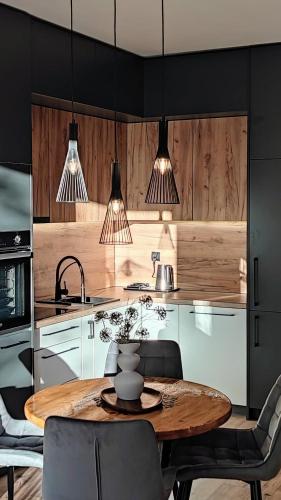 a kitchen with a wooden table and some chairs at Apartament w Bartoszycach in Bartoszyce
