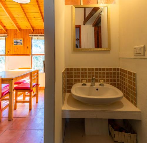a bathroom with a sink and a dining table at Casa al Río in El Chalten